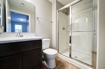 A bathroom with a shower and a sink and a toilet